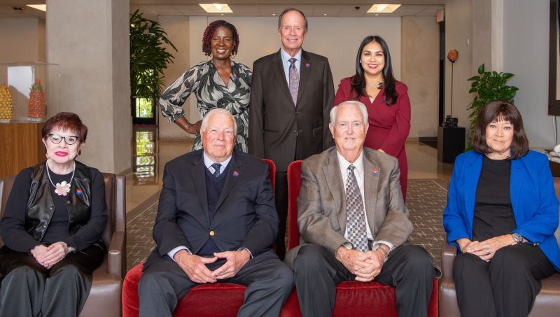 The 2025 Board of Trustees pose for a photo in the lobby of the admin building.