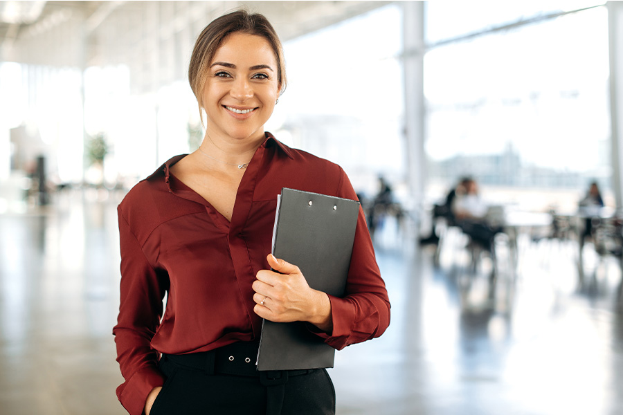 Smiling professionally dressed woman with clipboard
