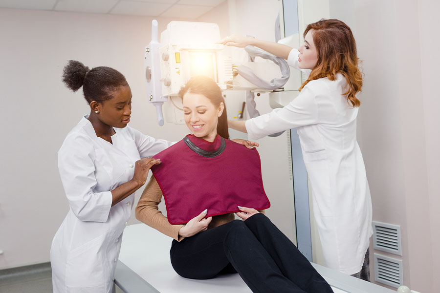 Technicians preparing a patient for x-ray