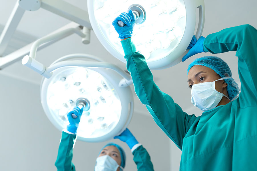 Tech adjusting medical lighting equipment