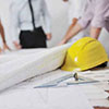 yellow construction hat and blueprints