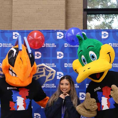 Mascots from Eastfield and Eastfield pose for a photo with a student