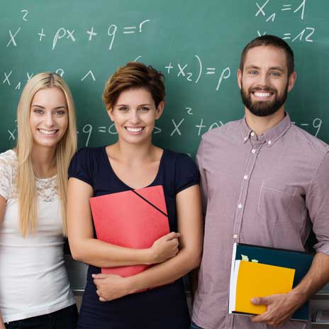Three students standing in front of a chalkboard with math equations