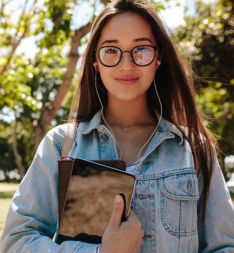 Student facing camera carrying notebooks