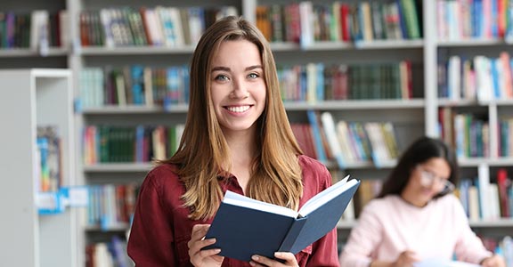 Student reading a book at a library