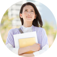 Student with folders in her arms looking up at the sky smiling