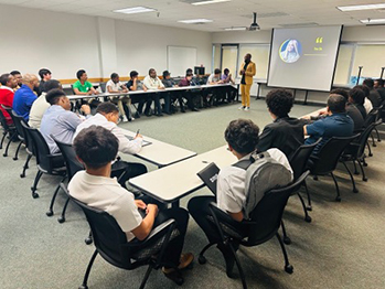 Students sit in around tables in a breakout session